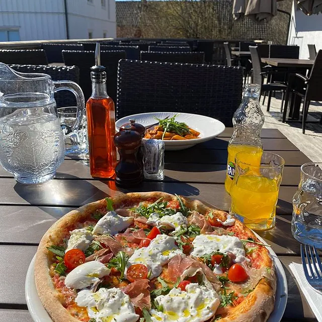 Steinovnsbakt pizza servert på uteserveringen.