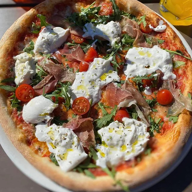 Italiensk pizza med burrata og skinke.