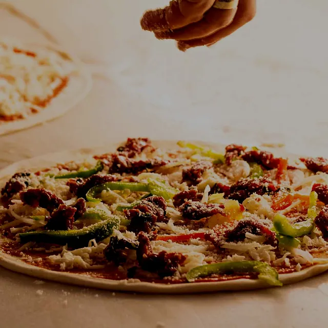 Topping legges på pizzaen.
