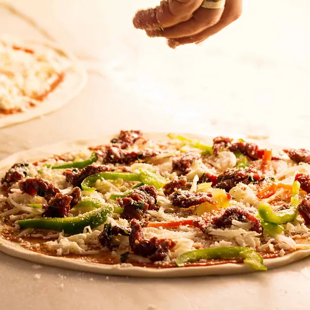 Topping legges på pizzaen.